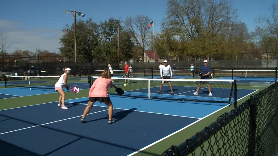Players enjoying doubles pickleball on outdoor courts